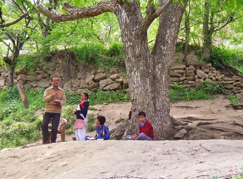 A trainer teaching students outdoors in India
